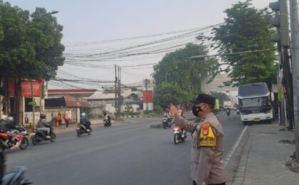 Pastikan Kelancaran Arus Pagi, Bhabinkamtibmas Harapan Mulya Gatur Lalin di Perempatan Pondok Ungu