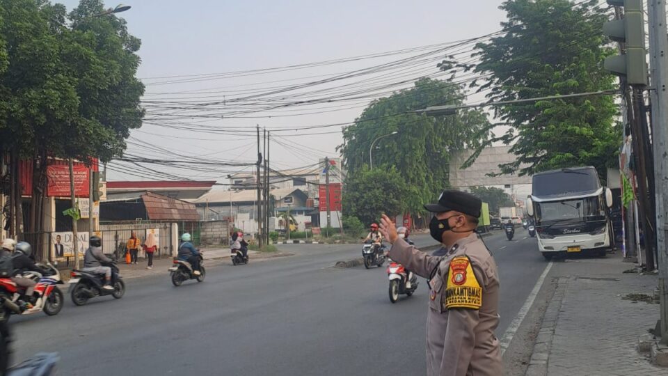 Pastikan Kelancaran Arus Pagi, Bhabinkamtibmas Harapan Mulya Gatur Lalin di Perempatan Pondok Ungu